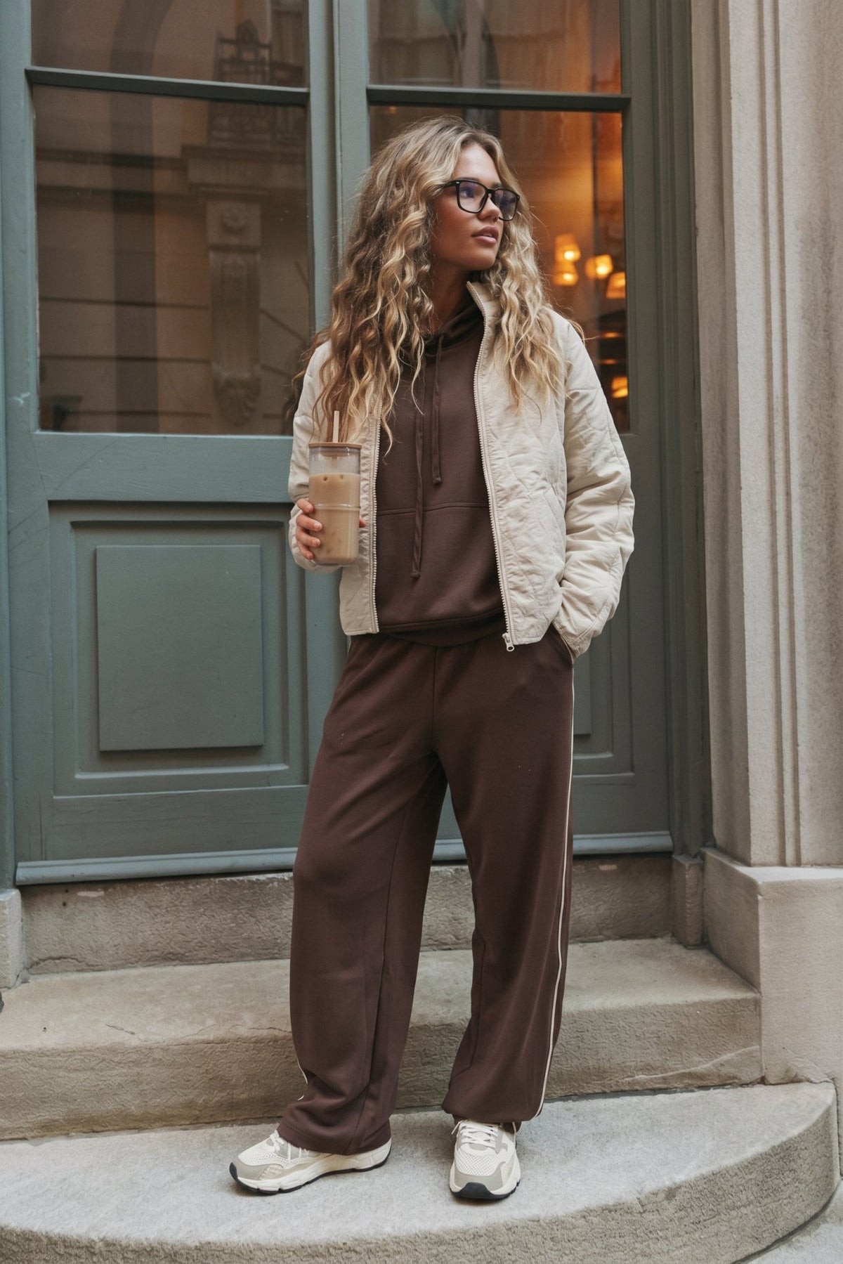 Women’s chocolate brown wide-leg sweatpants featuring a relaxed straight-leg silhouette, comfortable pull-on waistband, side pockets, and contrast ivory piping down the outer legs. Cozy lounge pants designed to coordinate with the matching chocolate brown hoodie, sold separately.