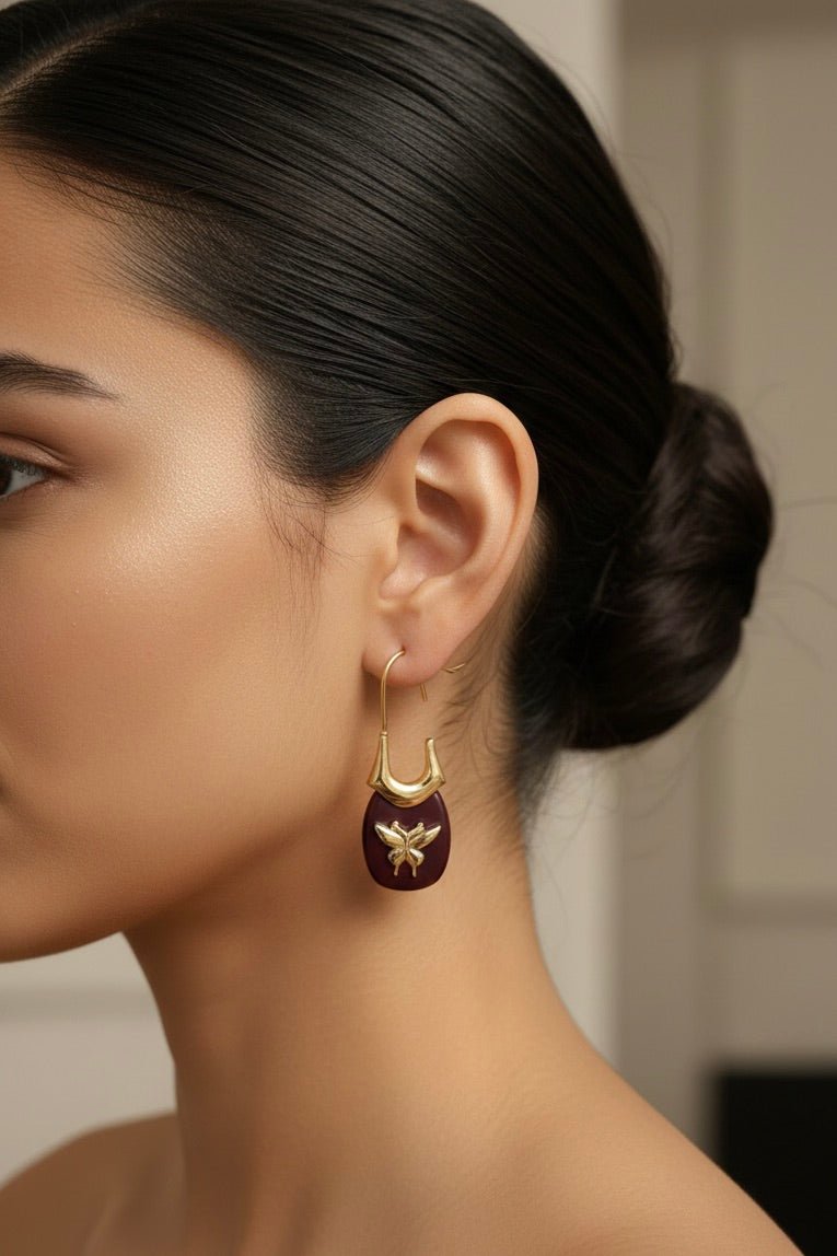 gold hardware earrings with butterfly decal and wood base