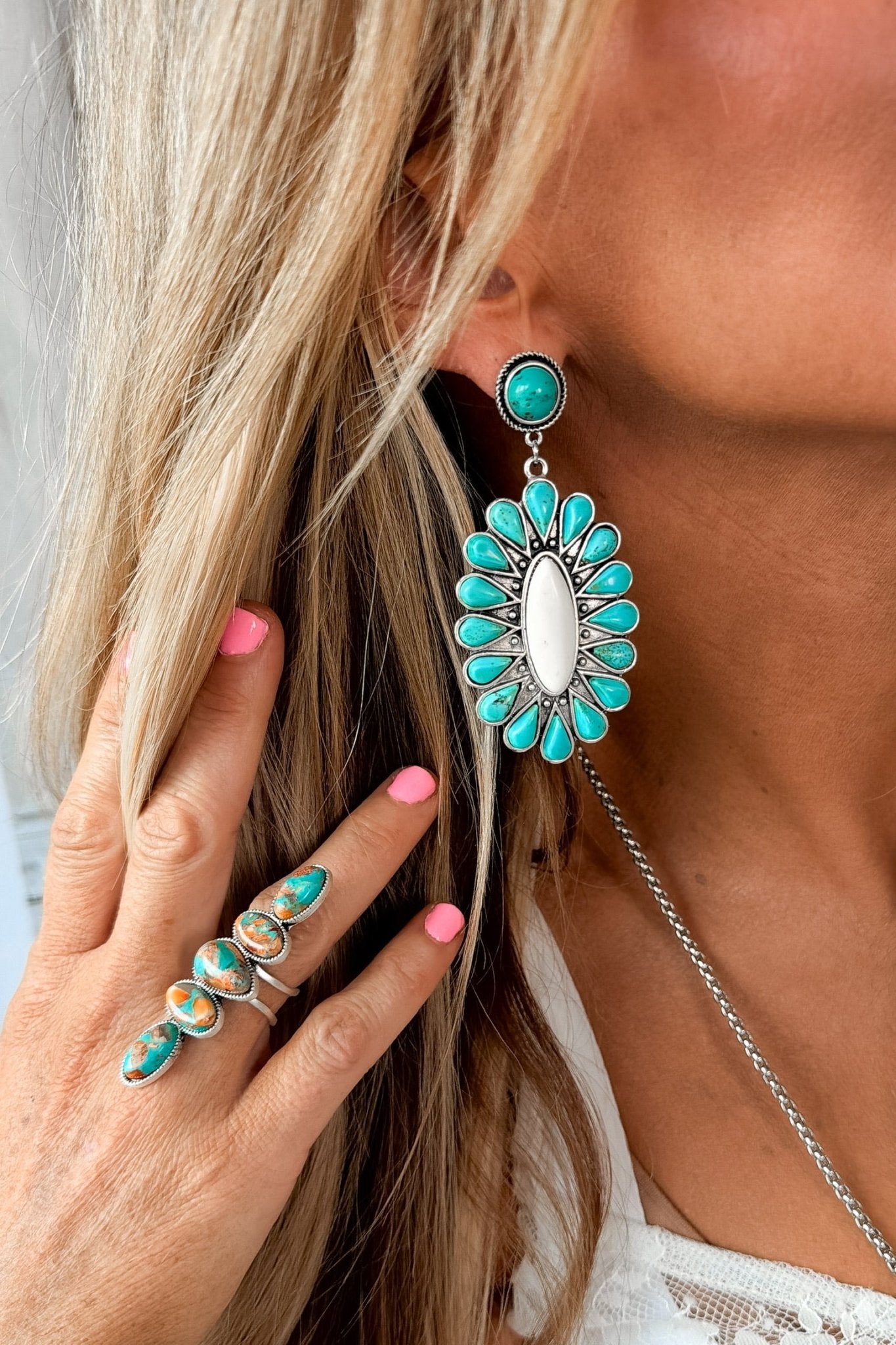 Southwestern turquoise drop earrings featuring a floral-inspired design with ivory center stones and antique silver detailing, perfect for western outfits, rodeos, and country concerts.