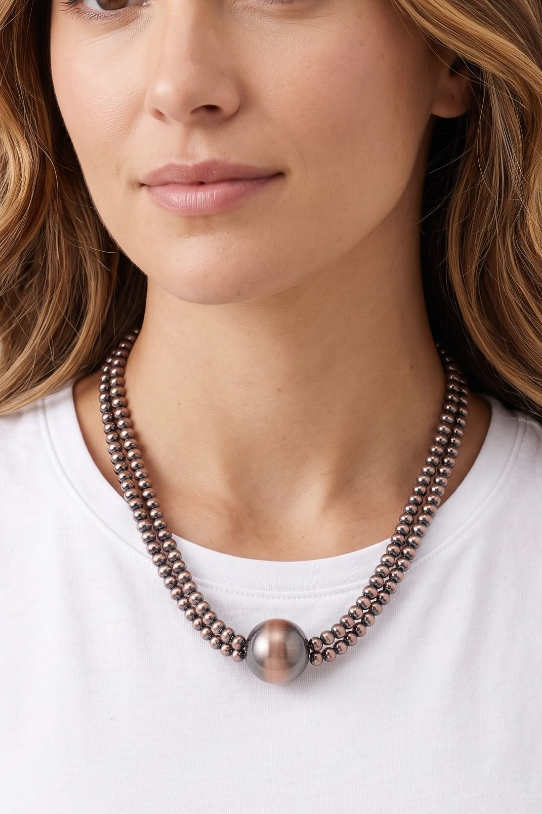 Western multi-strand metallic beaded necklace with oversized round center bead.