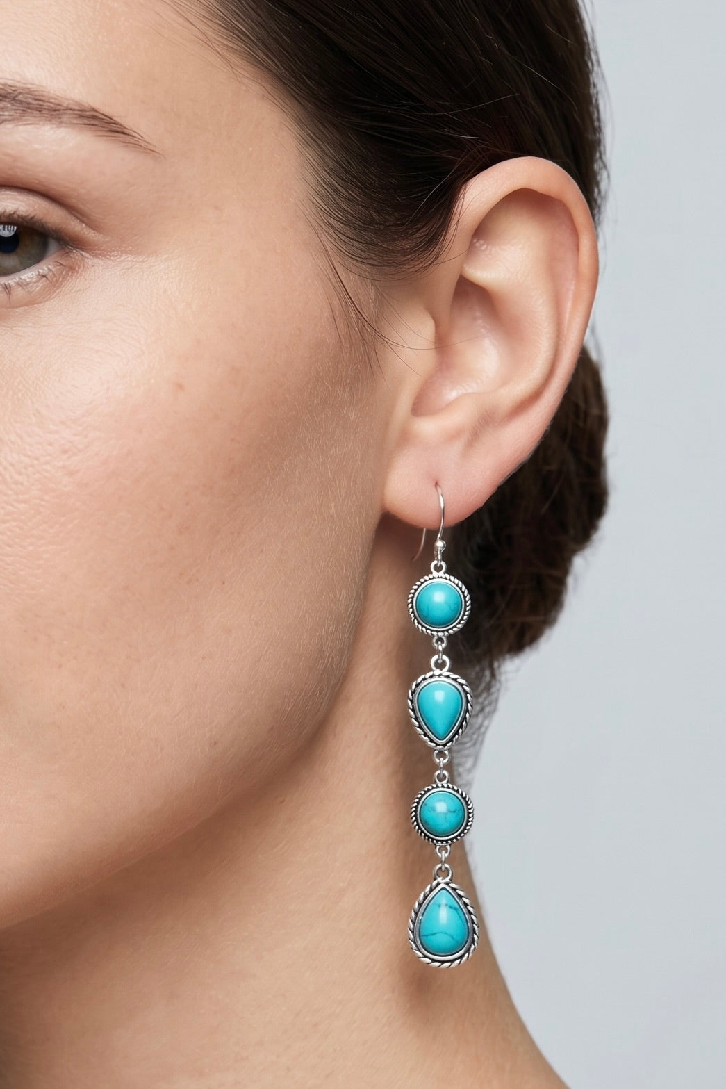 Long handmade turquoise dangle earrings with round and teardrop natural stones set in antique silver-plated metal with fish hook ear wires.