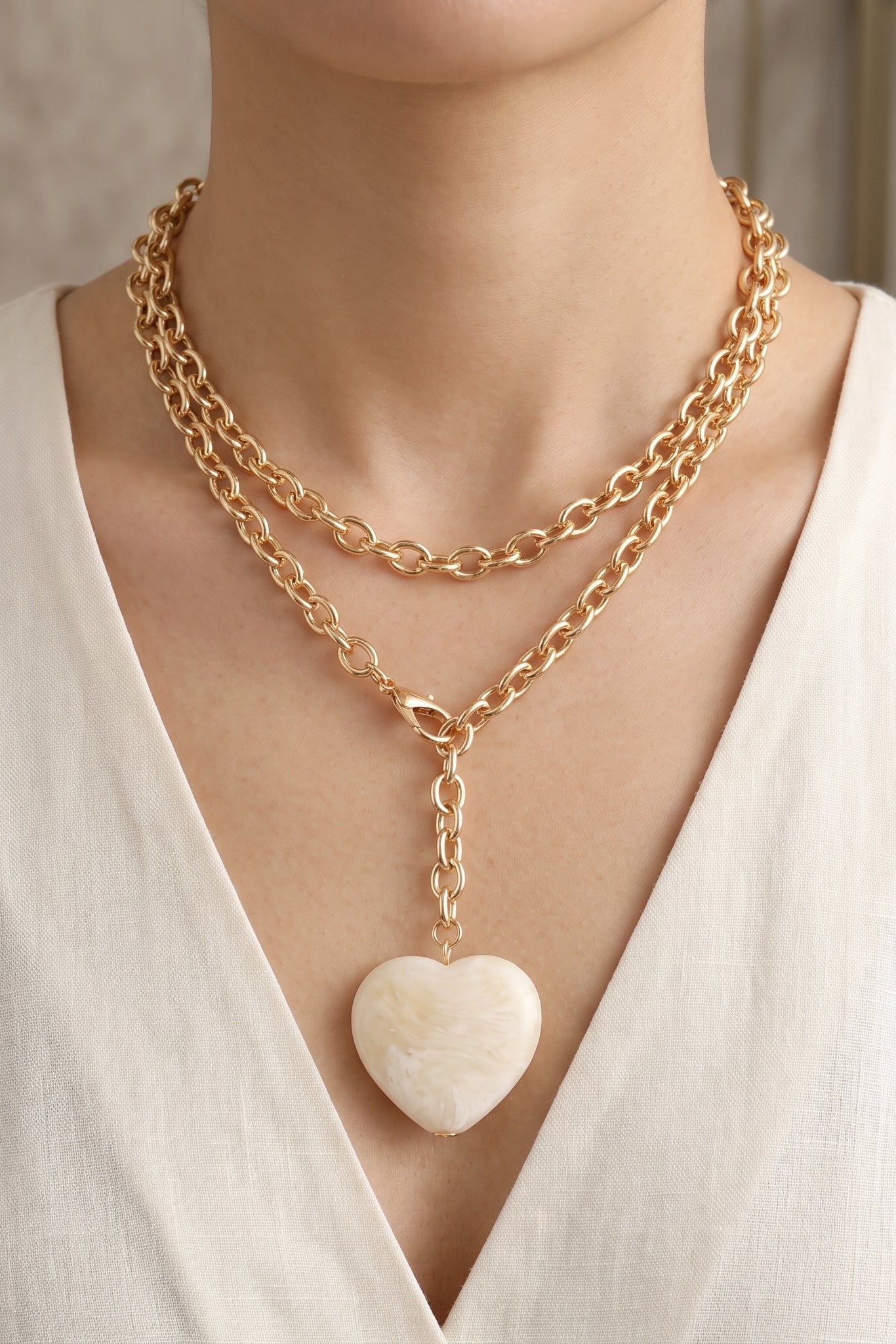 Pearly ivory oversized puffy acrylic heart pendant necklace with a long chunky gold-tone cable chain