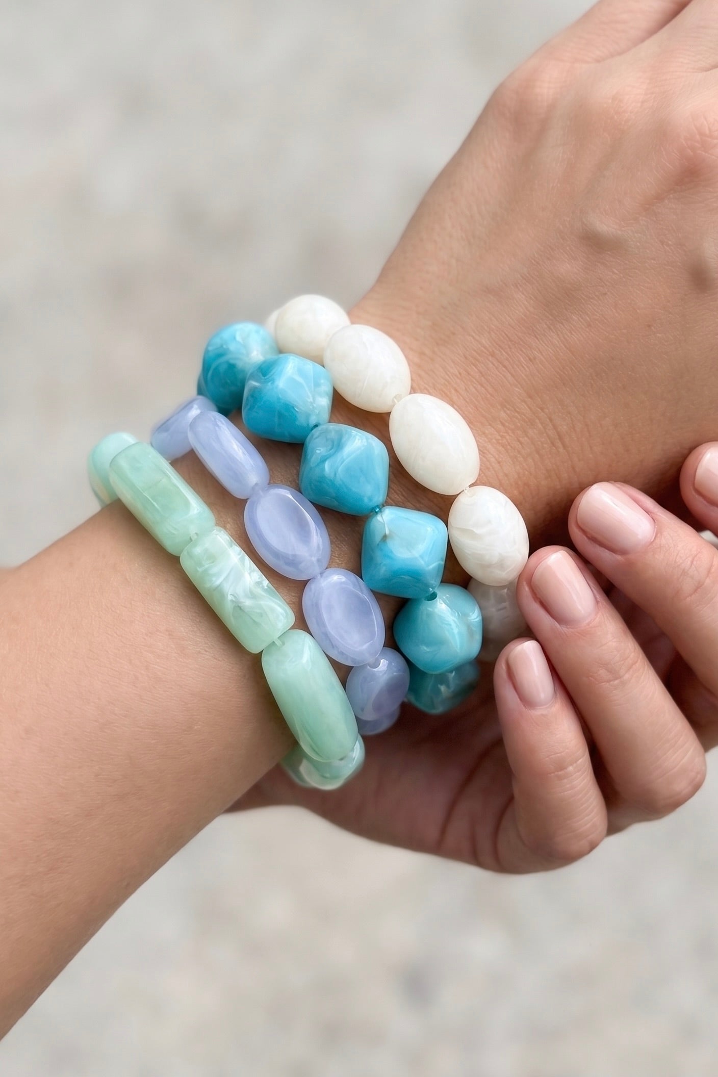 Coastal color bracelet stack featuring four chunky marbled acrylic stretch bracelets in turquoise, aqua, soft blue and ivory.