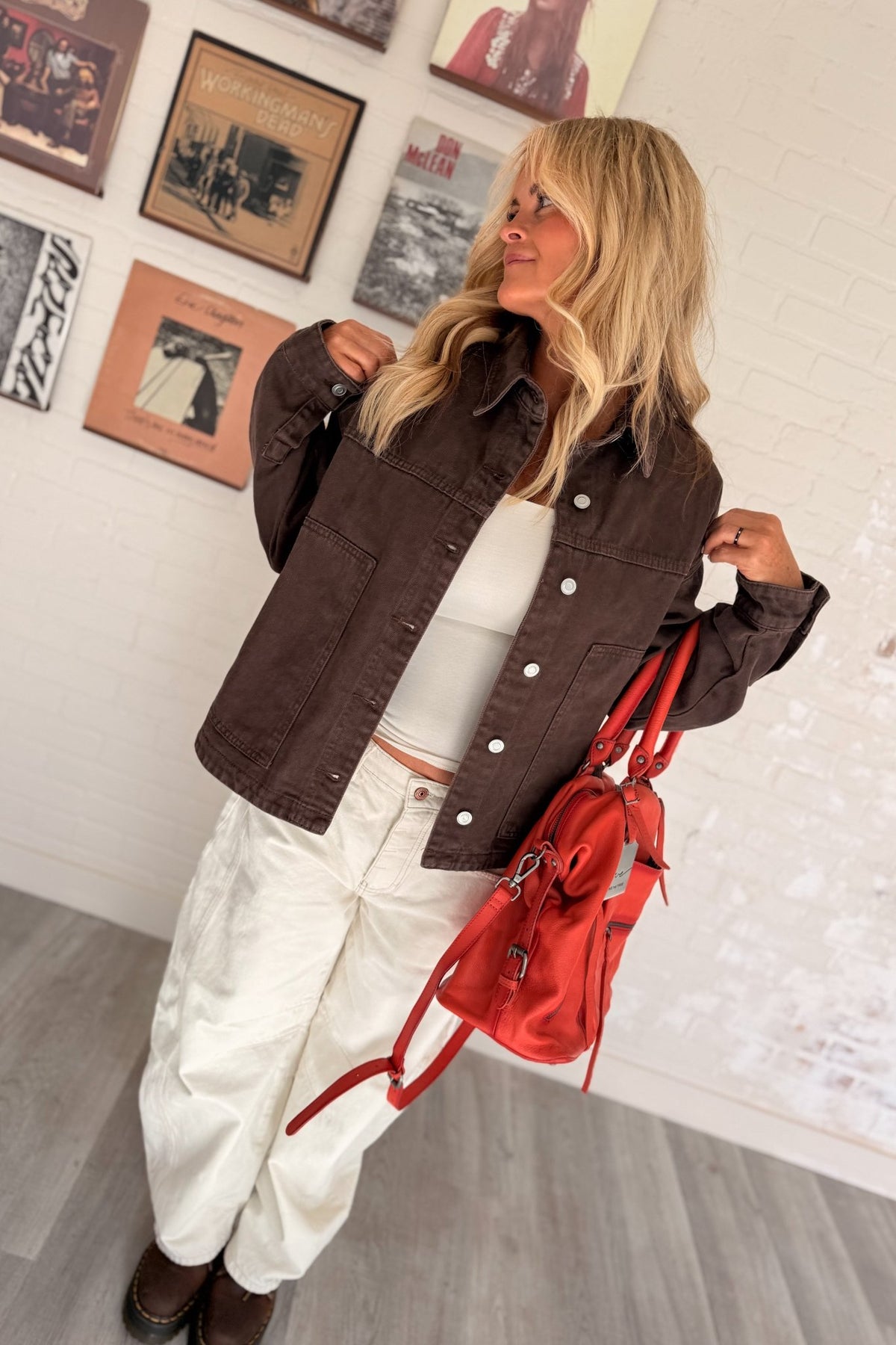 Women’s chocolate brown denim jacket featuring a relaxed boxy fit, collared neckline, silver button-front closure, long sleeves, dropped shoulders and oversized front patch pockets. A versatile brown denim layering jacket with a vintage-inspired washed look for casual fall outfits, everyday wear and transitional styling.