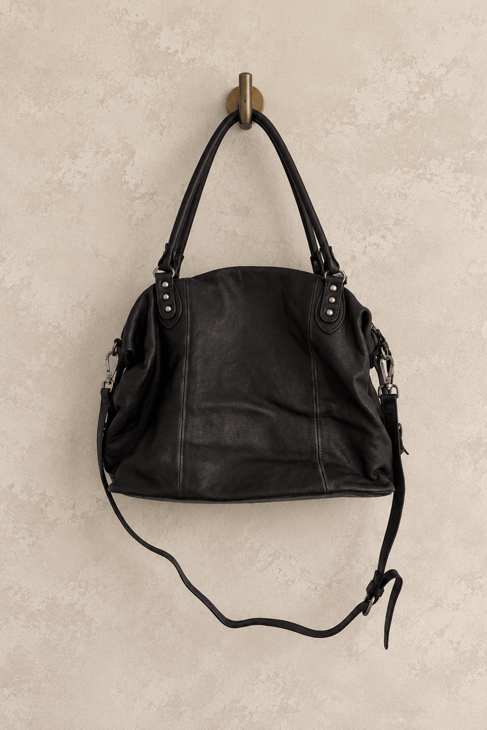 We The Free by Free People Emerson Tote Bag, a slouchy washed leather women’s carryall featuring a spacious interior, exterior zipper compartments, multiple pockets, buckle details, two top handles, adjustable detachable shoulder strap and zipper closure, available in Black, Saddle and Rusty Red.