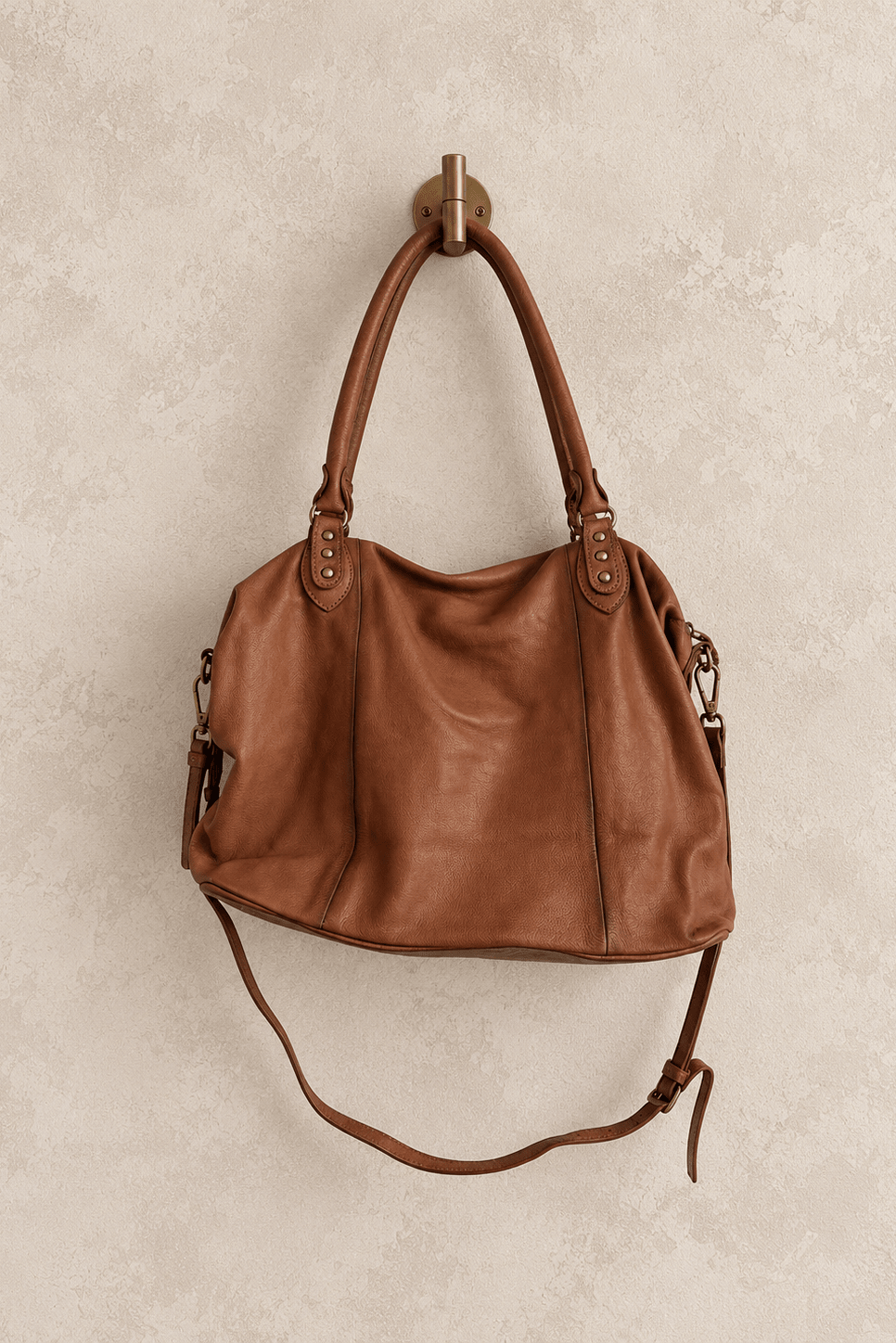 We The Free by Free People Emerson Tote Bag, a slouchy washed leather women’s carryall featuring a spacious interior, exterior zipper compartments, multiple pockets, buckle details, two top handles, adjustable detachable shoulder strap and zipper closure, available in Black, Saddle and Rusty Red.
