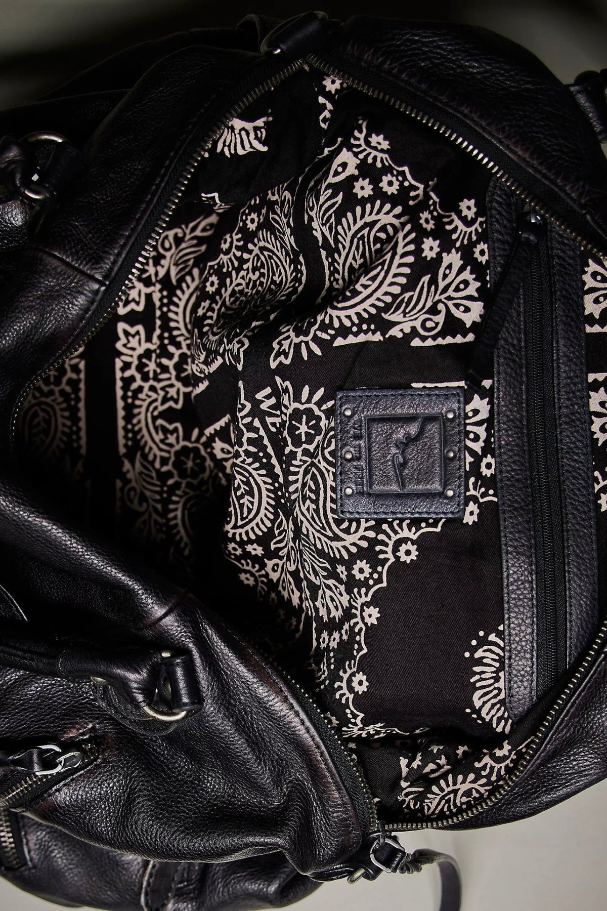 We The Free by Free People Emerson Tote Bag, a slouchy washed leather women’s carryall featuring a spacious interior, exterior zipper compartments, multiple pockets, buckle details, two top handles, adjustable detachable shoulder strap and zipper closure, available in Black, Saddle and Rusty Red.
