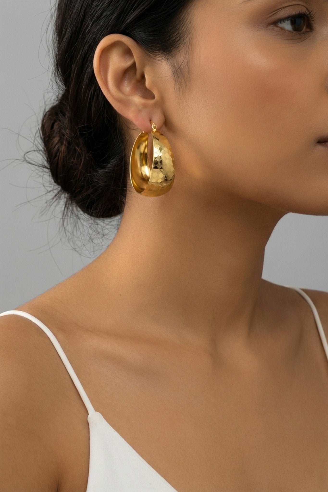 Close-up of Gilded Fig Textured Hoop Earrings featuring wide 18K gold-plated hoops with a polished hammered texture and secure clasp closure.