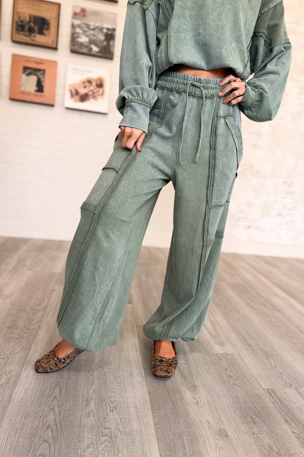 Women’s sage green mineral-washed two-piece lounge set featuring an oversized slightly cropped crewneck sweatshirt with exposed seam detailing and matching relaxed balloon jogger pants with an elastic drawstring waist, oversized patch pockets, exposed seams, and gathered ankles.