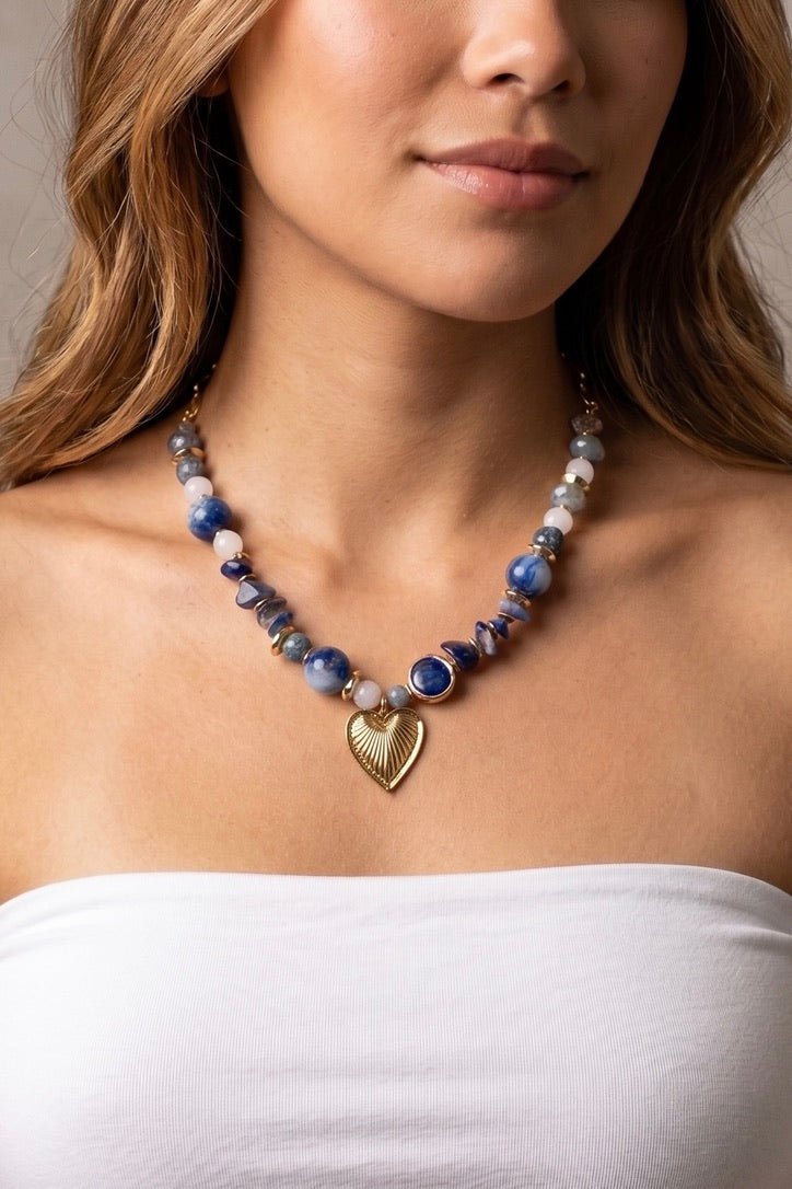 Blue stone beaded statement necklace featuring multi-toned blue gemstone beads and a gold heart pendant, perfect for summer outfits, coastal style, and boutique jewelry collections.