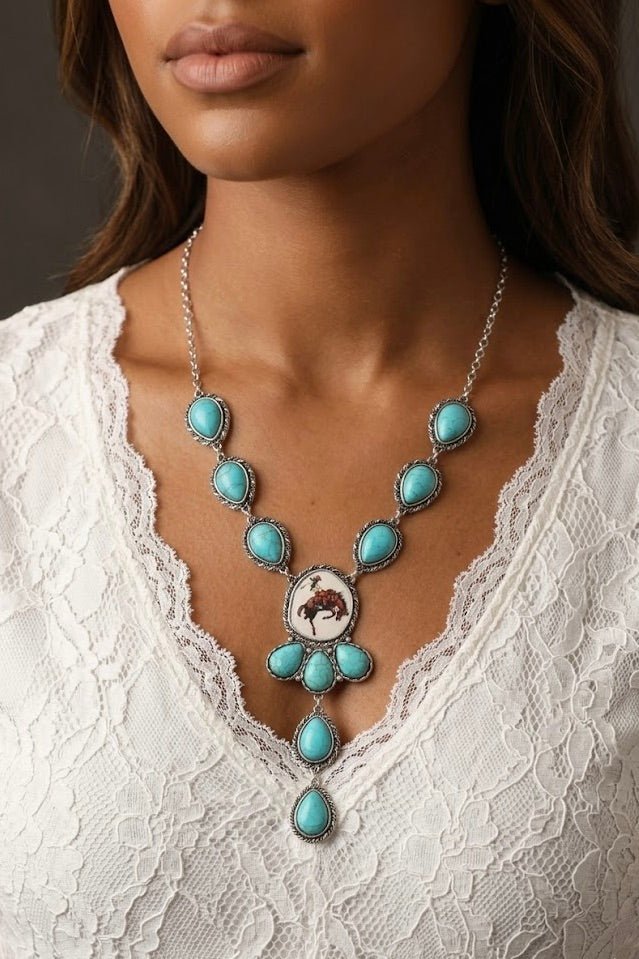 Turquoise western statement necklace with bronc rider pendant styled for country concert outfits, boho cowgirl fashion, rodeo style and western festival looks from Sand + Charcoal Boutique