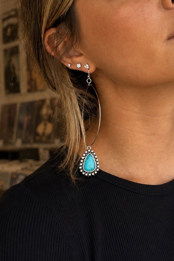 Large antique silver western hoop earrings with turquoise teardrop stone pendants and beaded detailing