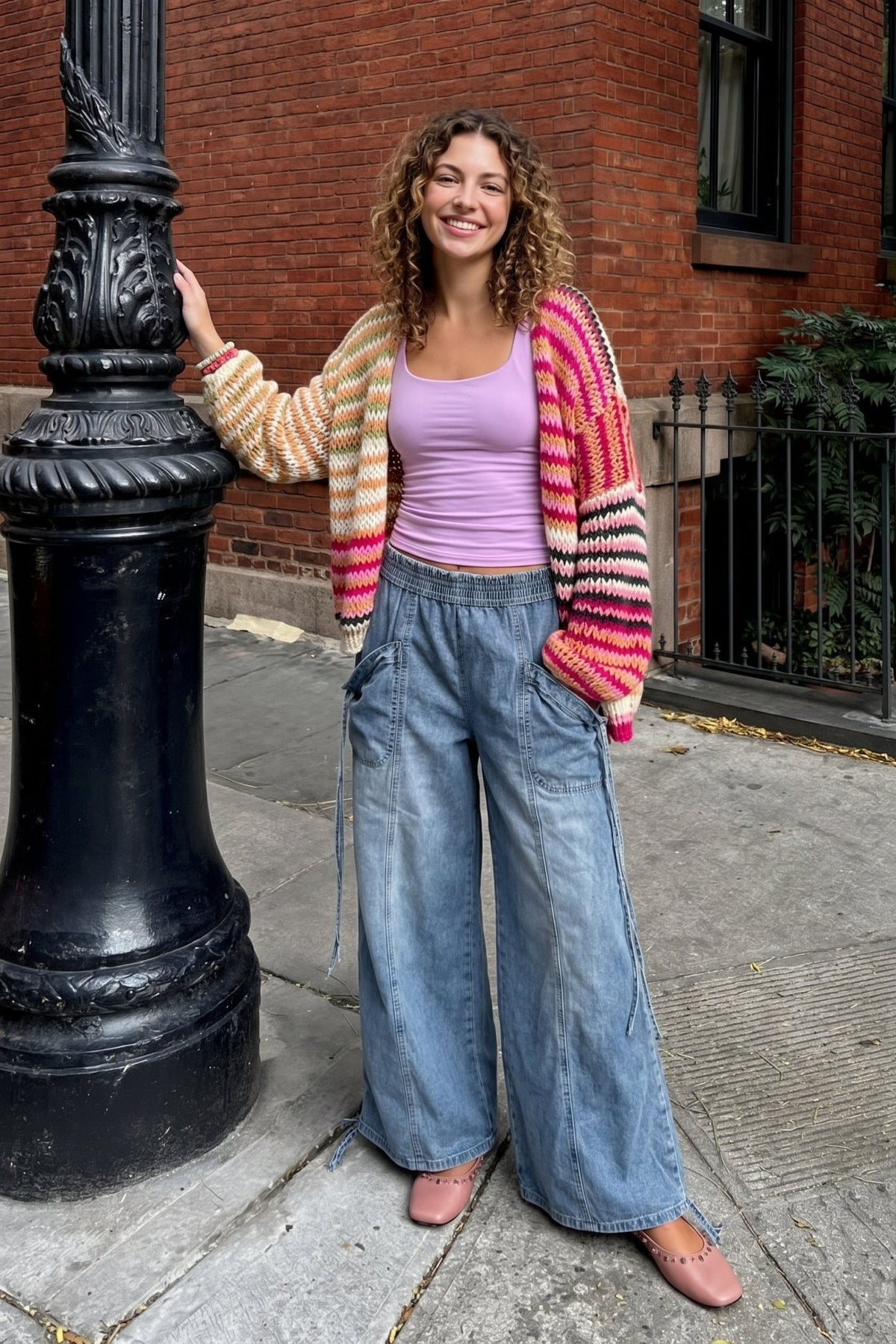 Light wash denim wide leg cargo pants with elastic waistband, oversized utility pockets, seam detailing, and relaxed slouchy fit.